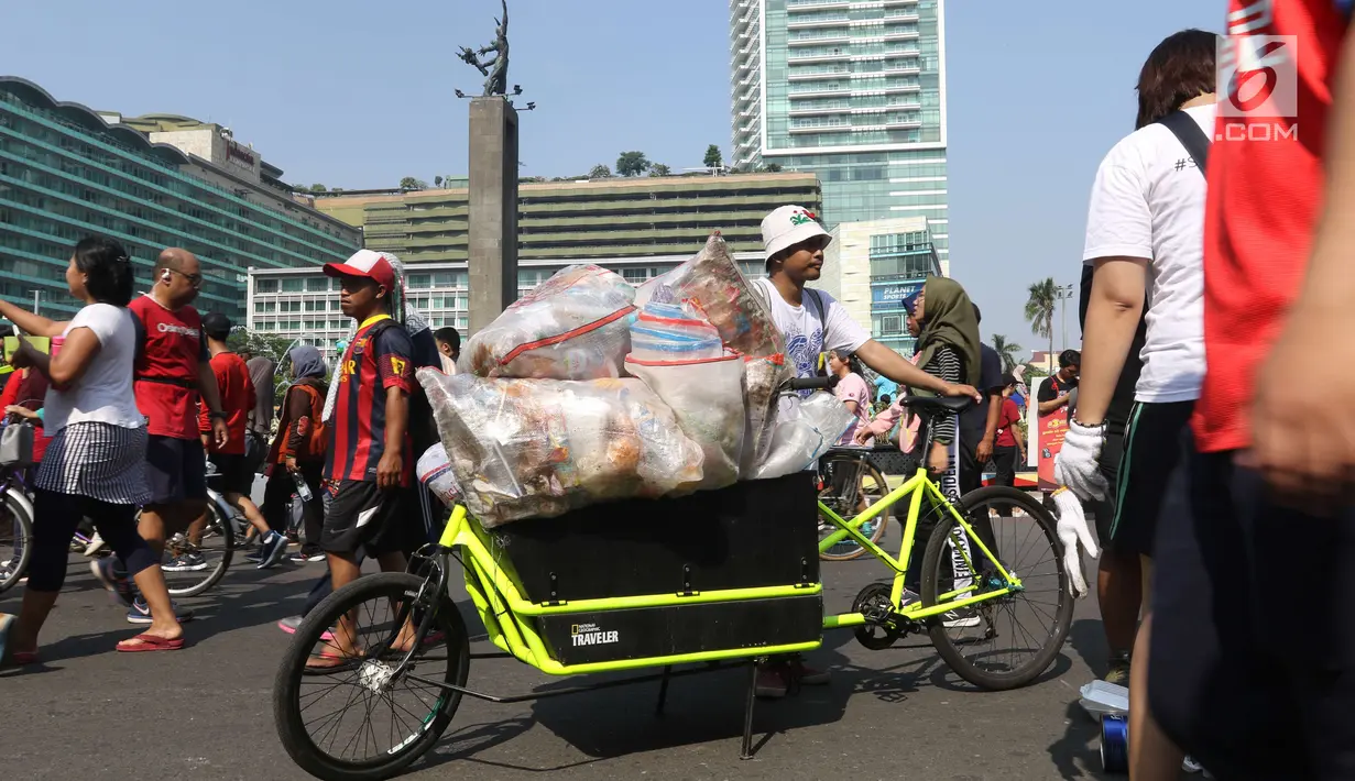 Relawan membawa karung berisi sampah plastik saat gerakan bersih sampah plastik di kawasan Car Free Day, Jakarta, Minggu (21/10). Gerakan itu untuk meningkatkan kesadaran masyarakat mengenai ancaman sampah plastik bagi Bumi. (Liputan6.com/Angga Yuniar)