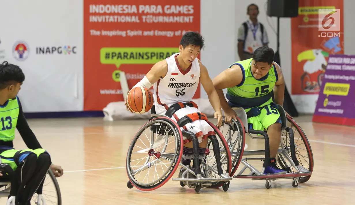Pebasket difable Indonesia, Donald P Santoso (tengah) mencoba menembus kawalan pemain Malaysia pada laga Indonesia Para Games Invitational Tournament 2018 di Hall A Senayan, Jakarta, Minggu (1/7). Indonesia unggul 54-53. (Liputan6.com/Helmi Fithriansyah)