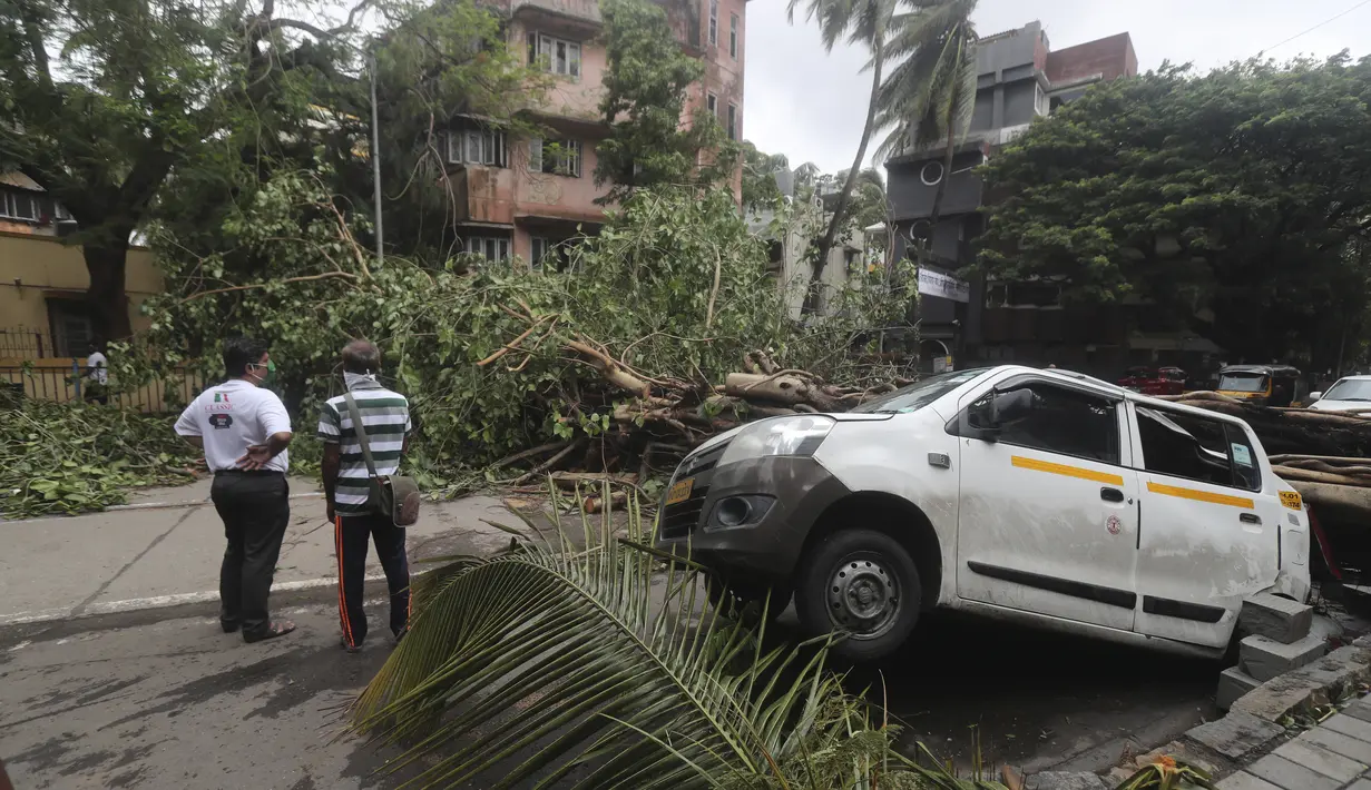 Sebuah mobil berdiri rusak dengan pohon tumbang setelah hujan lebat akibat siklon Tauktae di Mumbai India, pada Selasa (18/5/2021). Topan Tauktae disebut yang terbesar melanda wilayah itu dalam beberapa dekade terakhir.  (AP Photo/Rafiq Maqbool)