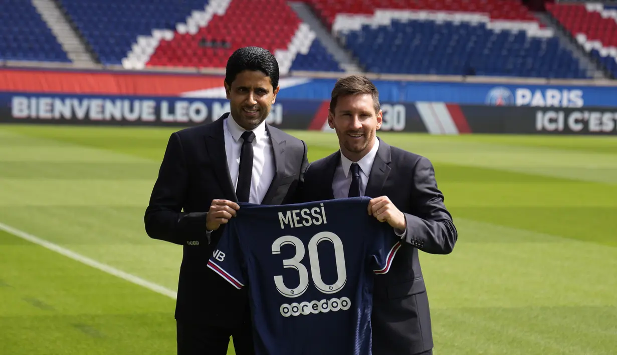 Presiden PSG Nasser al-Khelaifi berpose bersama Lionel Messi sambil mengangkat kaus nomor 30 sambil di lapangan stadion Parc des Princes di Paris, Rabu (11/8/2021). Messi dikontrak oleh PSG selama dua tahun dengan opsi perpanjangan setahun di klub kaya Paris itu. (AP Photo/Francois Mori)