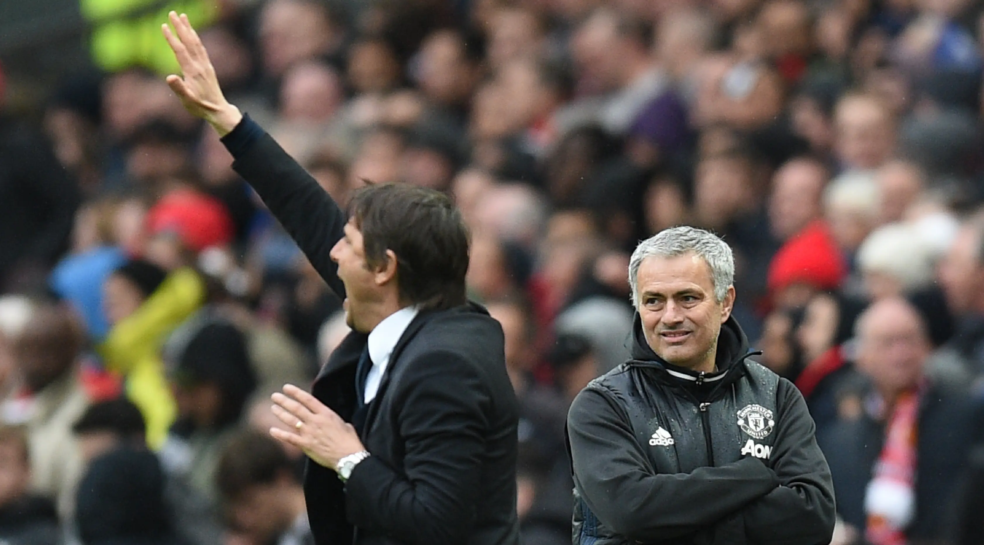 Pelatih MU, Jose Mourinho melihat Antonio Conte mengintruksikan para pemainnya saat bertanding pada lanjutan Liga Inggris di Old Trafford, Inggris (16/4). MU mengalahkan Chelsea dengan skor 2-0. (AFP Photo / Oli Scarff)