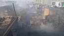 Petugas pemadam kebakaran melakukan pendinginan kawasan pemukiman padat penduduk yang terbakar di kawasan Manggarai, Jakarta, Selasa (13/8/2024). (merdeka.com/Imam Buhori)