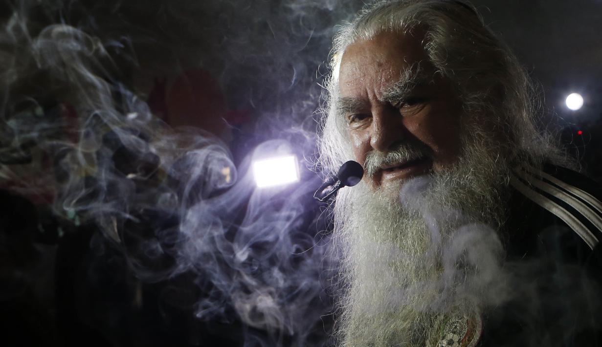 Peramal asal Meksiko, Antonio Vazquez, membaca mantra saat melakukan ritual di Meksiko City, Rabu (13/6/2018). Ritual tersebut dilakukan agar Timnas Meksiko sukses di Piala Dunia 2018. (AP/Marco Ugarte)
