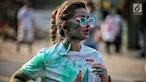 Seorang wanita saat mengikuti lari santai The Color Run di kawasan komplek Gelora Bung Karno, Jakarta, Minggu (16/9). Sebanyak 13.000 peserta mengikuti The Color Run. (Liputan6.com/Faizal Fanani)