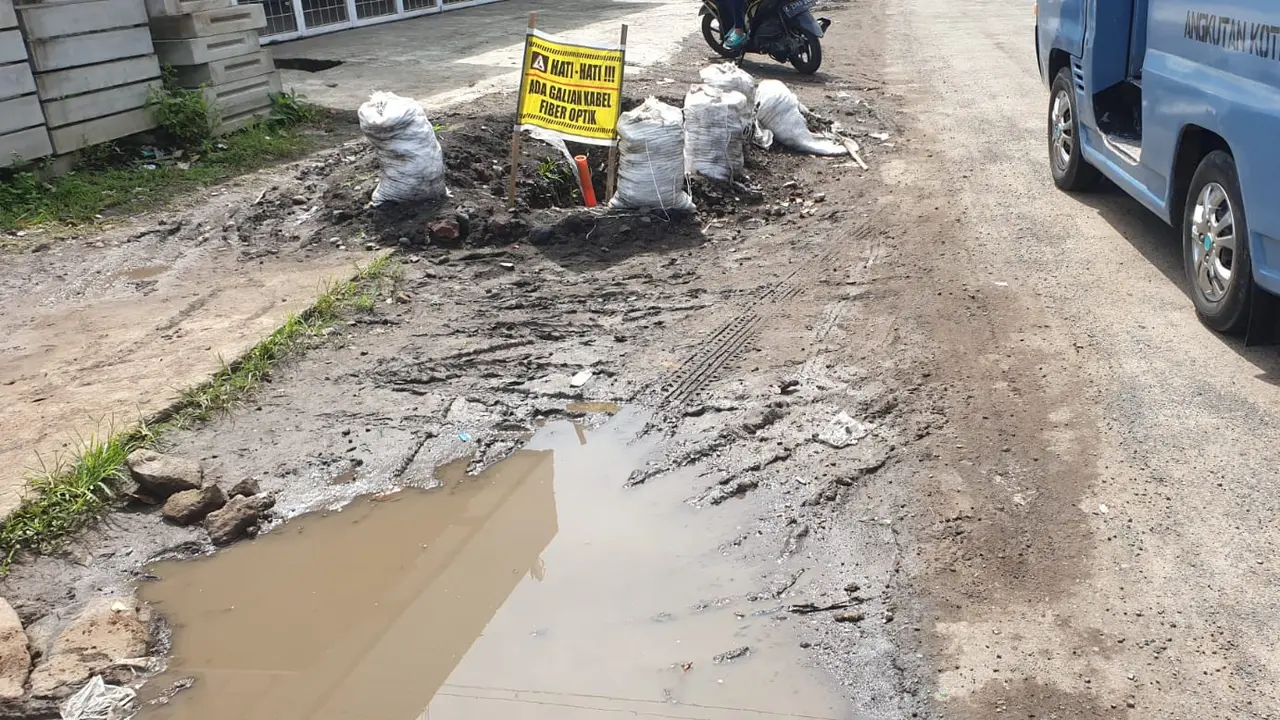 Bekas galian fiber optik di jalan terusan Aruji dekat kompleks SOR Ciateul, kecamatan Tarogong Kidul, dibiarkan berantakan tanpa perbaikan. (Liputan6.com/Jayadi Supriadin)