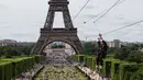 Seorang wanita meluncur dengan seutas tali saat melakukan flying fox dari Menara Eiffel, Paris, 5 Juni 2017. Kesempatan ini dibuka untuk umum jelang turnamen tenis French Open agar dapat merasakan bagaimana kecepatan bola tenis (AP Photo/Kamil Zihnioglu)