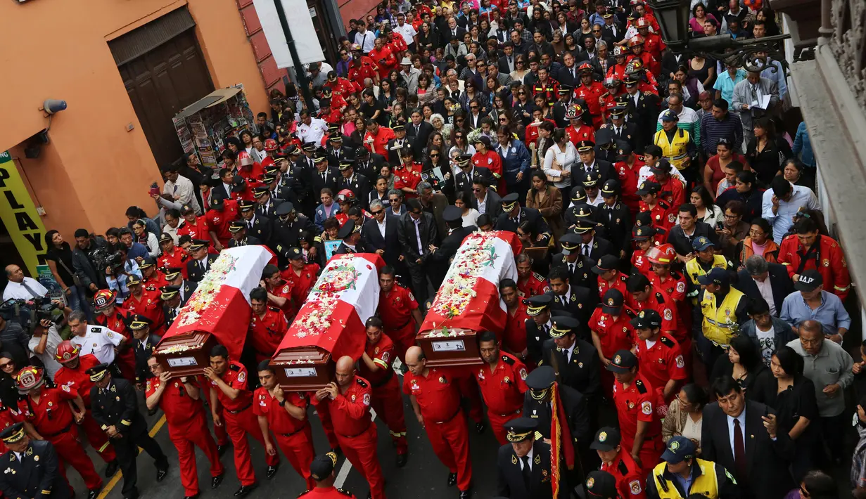 Ribuan warga, beserta petugas dan kerabat mengiringi upacara pemakaman tiga petugas pemadam kebakaran yang tewas di sebuah pabrik sepatu di kota Lima, Peru (21/10). (Reuters/Guadalupe Pardo)