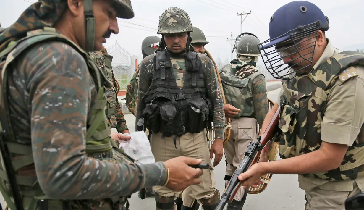 Seorang perwira tentara mengisi senjatanya saat ingin membubarkan aksi demontrasi usai salat Idul Fitri di Srinagar, India (26/6). Pasukan keamanan setempat berusaha membubarkan para demonstran dengan menembakan gas air mata. (AP Photo / Mukhtar Khan)
