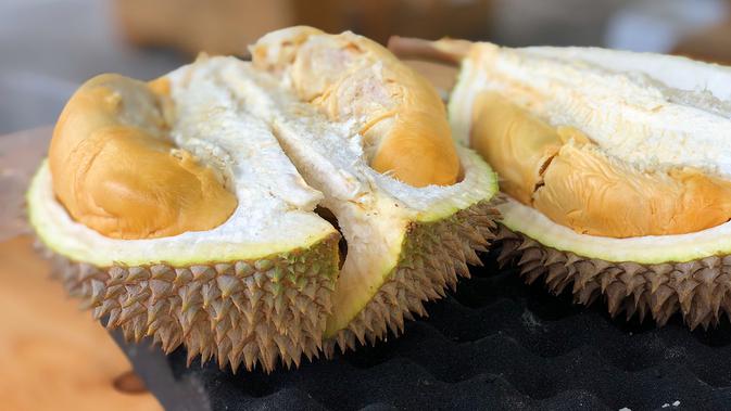 Mengonsumsi Buah Durian (Photo by Jim Teo on Unsplash)