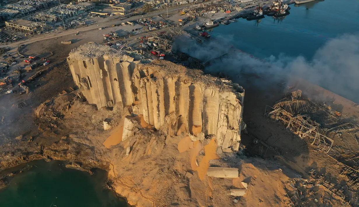 Dalam gambar drone ini, silo yang hancur berada di antara puing-puing setelah ledakan di pelabuhan Beirut, Lebanon, Rabu (5/8/2020). Ledakan di kawasan pelabuhan itu mengguncangkan seluruh ibu kota, mengguncang bangunan, dan menebarkan kepanikan di antara warganya. (AP Photo/Hussein Malla)