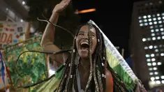 Seorang peserta pesta jalanan yang dikenal sebagai blocos, menari selama protes terhadap pembatasan oleh pejabat kota di Rio de Janeiro, Brasil (13/4/2022). Balai Kota telah melarang pesta jalanan selama perayaan Karnaval, yang tertunda hampir dua bulan karena pandemi. (AP Photo/Silvia Izquierdo)