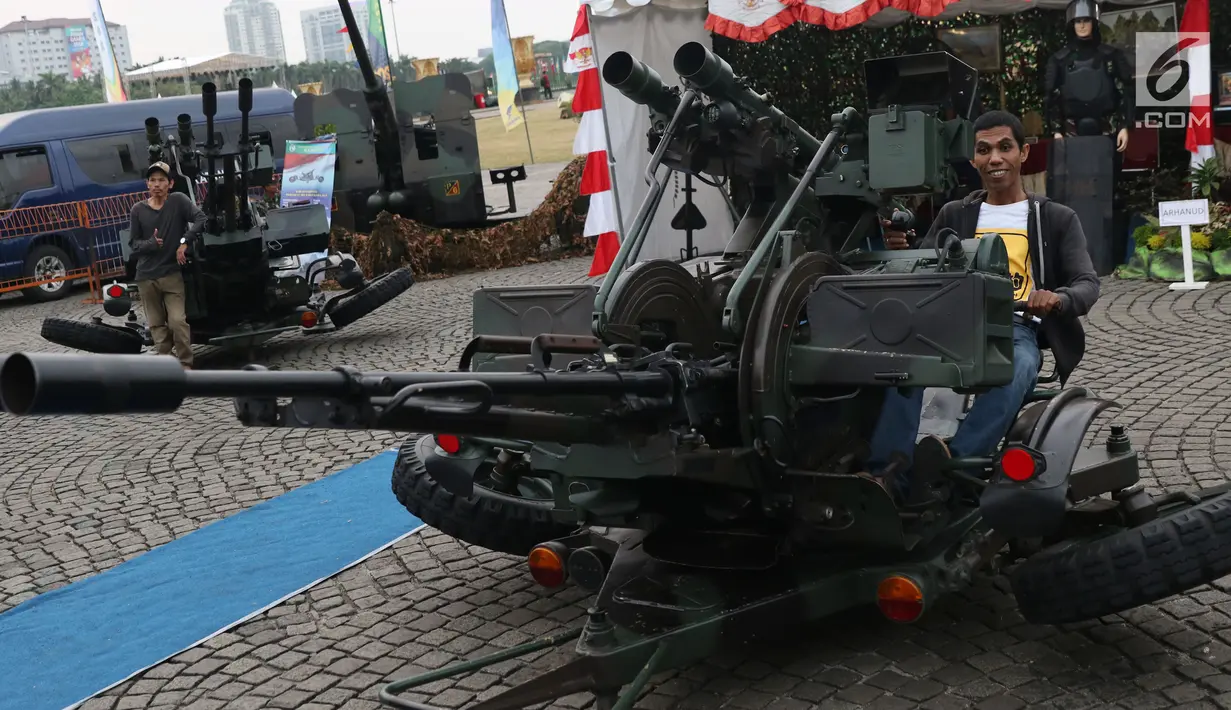 Warga bergaya di atas alat tempur pertahanan udara TNI pada pameran Alat Utama Sistem Persenjataan TNI di Kawasan Monas, Jakarta, Kamis (27/9). Pameran ini bagian perayaan HUT TNI ke-73. (Liputan6.com/Helmi Fithriansyah)