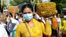 Umat Hindu membawa sesaji saat akan berdoa pada perayaan Hari Raya Kuningan di Pura Sakenan, Pulau Serangan, Denpasar, Bali, Sabtu (20/11/2021). Kuningan merupakan hari terakhir perayaan Galungan yang diyakini sebagai hari naiknya roh suci leluhur kembali ke surga. (Sonny TUMBELAKA/AFP)