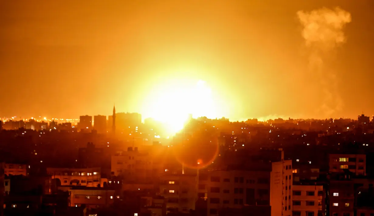 Ledakan terlihat selama serangan udara Israel di kota Gaza, Palestina (27/10). Israel mebombardir ke sejumlah titik di Jalur Gaza, termasuk beberapa di antaranya diyakini sebagai markas Hamas. (AFP Photo/Mahmud Hams)
