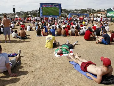 Sejumlah suporter menyaksikan laga Albania melawan Swiss sambil bersantai di area fan zone yang terletak di tepi pantai kawasan Marseille, Prancis, Sabtu (11/6/2016). (AFP/Jean Christophe Magnenet)