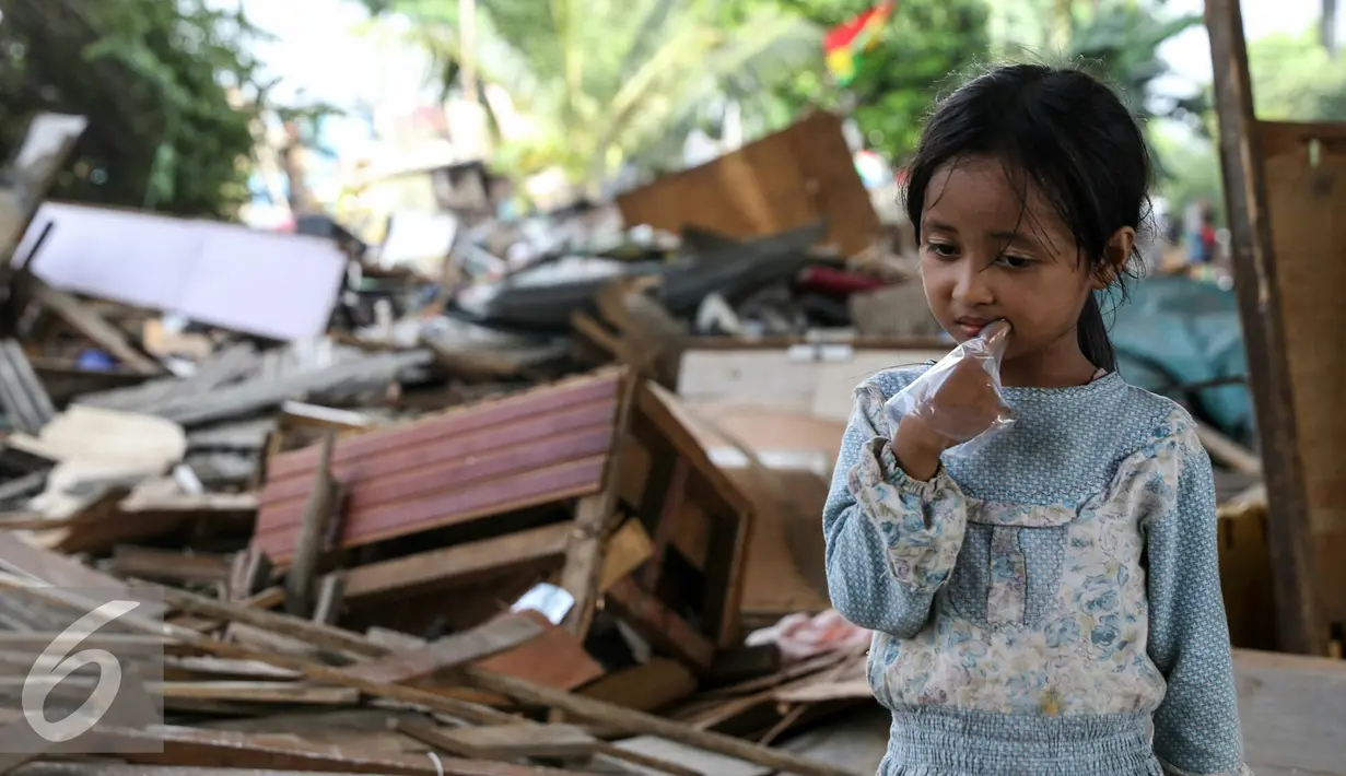 Seorang anak berdiri tepat diatas kamar tidurnya di tengah kolong tol pluit yang telah rata dengan tanah usai ditertibkan petugas Satpol PP, Jakarta, Rabu (2/3). (Liputan6.com/Yoppy Renato)