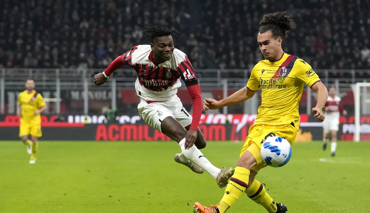 Penyerang AC Milan, Rafael Leao menembak bola dari kawalan pemain Bologna, Arthur Theate pada pertandingan Liga Serie A Italia di stadion San Siro, Italia (5/4/2022). AC Milan bermain imbang atas Bologna 0-0. (AP Photo/Antonio Calanni)