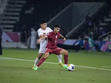 Gelandang Timnas Indonesia U-23 Witan Sulaeman mencoba merebut bola dari kaki gelandang Timnas Qatar U-23 Abdullah Al-Yazidi dalam laga fase grup Piala Asia U-23 2024 di Stadion Jassim bin Hamad pada Senin (15/4/2024) malam WIB. (Dok. PSSI)