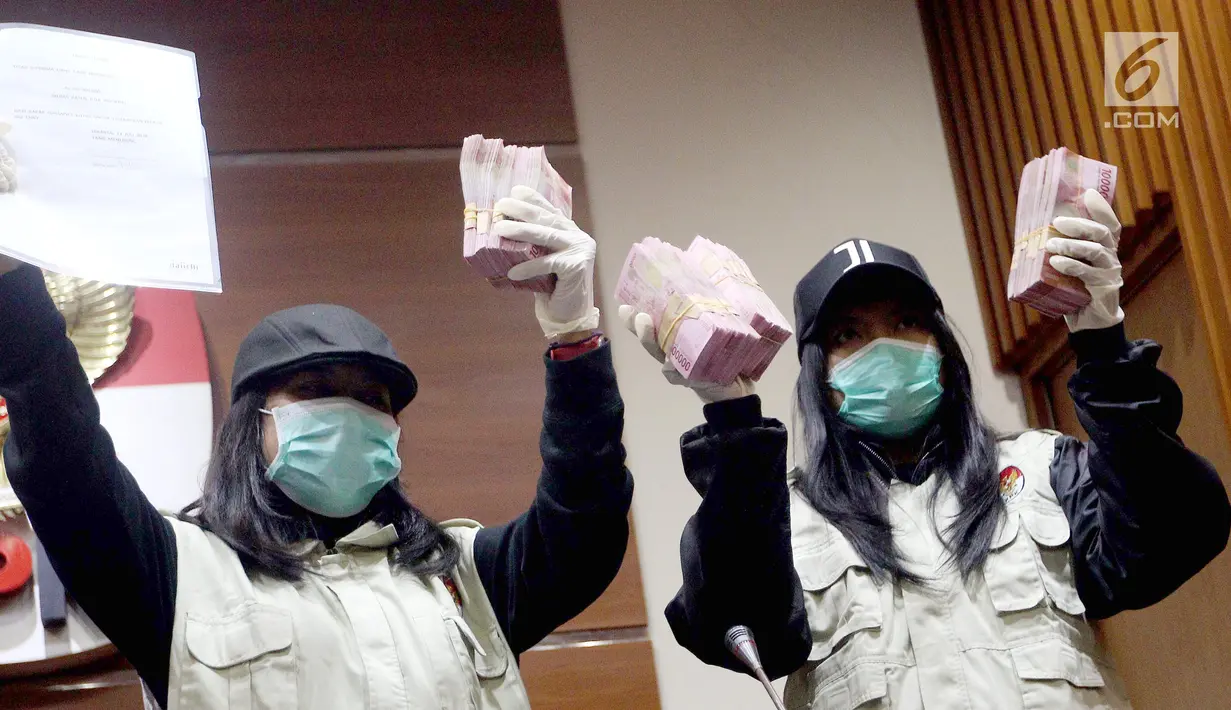 Dua penyidik KPK menunjukkan barang bukti OTT uang Rp 500 juta di Gedung KPK Jakarta, Sabtu (14/7). Dua tersangka Eni Maulani Saragih sebagai penerima hadiah dan Johannes Budisutrisno Kotjo sebagai pemberi hadiah. (Liputan6.com/Johan Tallo)