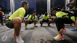 Peserta melakukan pemanasan sebelum mulai berlari dalam Jakarta Ultra 100K, Sabtu (12/11). Lomba lari ultra ini merupakan race ultra pertama dengan jarak tiap etape 25 kilometer. (Liputan6.com/Fery Pradolo)