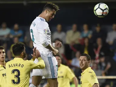 Pemain Real Madrid, Cristiano Ronaldo menyundul bola melewati adangan pemain Villarealpada laga terakhir La Liga di Ceramica stadium, Villarreal, (19/5/2018). Real Madrid bermain imbang 2-2. (AFP/Jose Jordan)