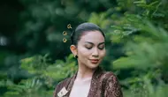 Tampil anggun dalam balutan kebaya kutubaru cokelat dan kain batik lawas, Ariel menghadirkan interpretasi modern tentang kecantikan perempuan Indonesia yang berakar kuat pada tradisi. [@didietmaulana].