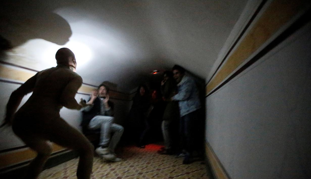 Ekspresi ketakutan pengunjung saat menemui hantu di Quinta Nova da Assuncao, Belas, Portugal (13/5). Rumah hantu ini berisi 25 kamar dipenuhi penampakan bayangan dan suara dari pintu yang menutup secara acak. (REUTERS/Rafael Marchante)