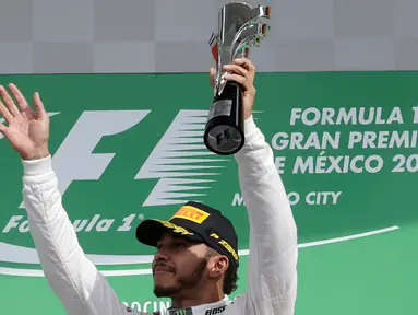 Pembalap tim Mercedes, Lewis Hamilton mengangkat trofi , setelah menjuarai balapan F1, di Grand Prix Meksiko yang berlangsung di Sirkuit Autodromo Hermanos Rodriguez, Mexico City, Meksiko (30/10). (Reuters/Henry Romero)