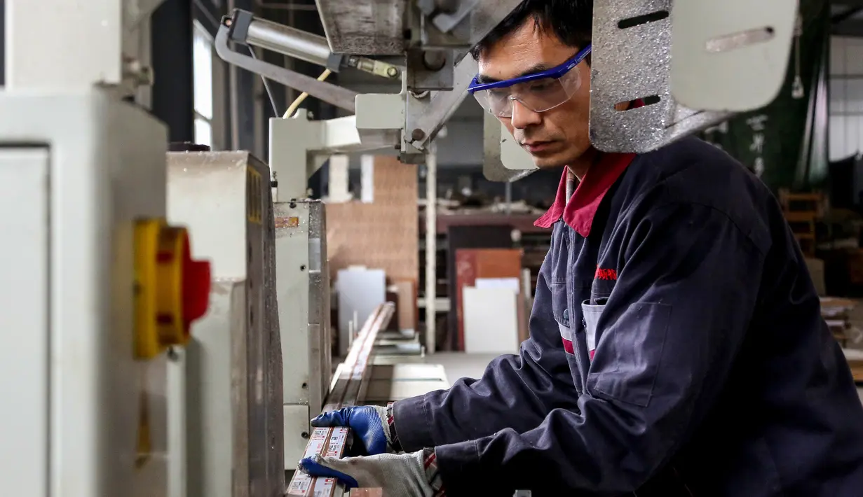 Seorang karyawan mengerjakan produk aluminium di sebuah pabrik di Zouping di provinsi Shandong bagian timur China (23/11/2019). (AFP Photo/STR)