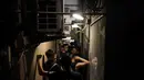 Turis berjalan di sepanjang lorong sempit di luar restoran ramen di Golden Gai di distrik Shinjuku Tokyo (26/7/2019). Di area ini, pengambilan foto dan video untuk semua keperluan di jalan dilarang tanpa izin dari asosiasi promosi bisnis di daerah tersebut. (AP Photo / Jae C. Hong)