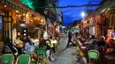 Orang-orang makan di sebuah restoran di kota pesisir Israel, Tel Aviv, Minggu (7/3/2021). Israel mengambil langkah lain menuju keadaan normal pasca-pandemi, dengan sekitar 40 persen populasi sepenuhnya telah diinokulasi untuk melawan virus corona COVID-19.  (Emmanuel DUNAND/AFP)