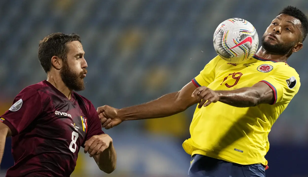 Penyerang timnas Kolombia, Miguel Borja dan gelandang Venezuela, Francisco La Mantia berebut bola pada laga kedua Grup B Copa America 2021 di Estadio Olimpico Pedro Ludovico Teixeira, Golania, Brasil, Jumat (18/6/2021). Timnas Kolombia dan Venezuela bermain imbang 0-0. (AP Photo/Ricardo Mazalan)