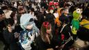 Orang-orang dengan kostum berjalan menyeberangi persimpangan jalan yang terkenal saat perayaan Halloween di distrik hiburan Shibuya, Tokyo, Jepang, 31 Oktober 2022. (AP Photo/Hiro Komae)