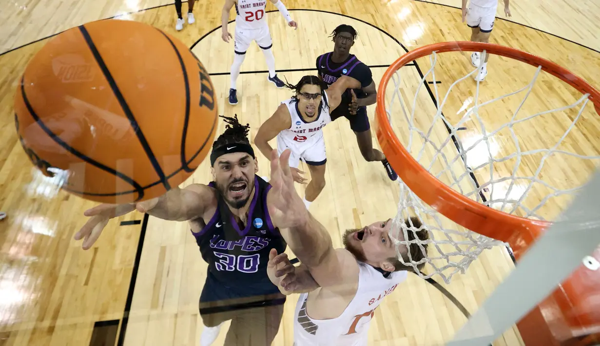 Pemain Grand Canyon Antelopes, Gabe McGlothan melakukan lay up saat laga putaran pertama Divisi I NCAA melawan Saint Mary yang berlangsung di Spokane Veterans Memorial Arena, Washington, Amerika, Minggu (23/03/2024) WIB. (AFP/Getty Images/Steph Chambers)