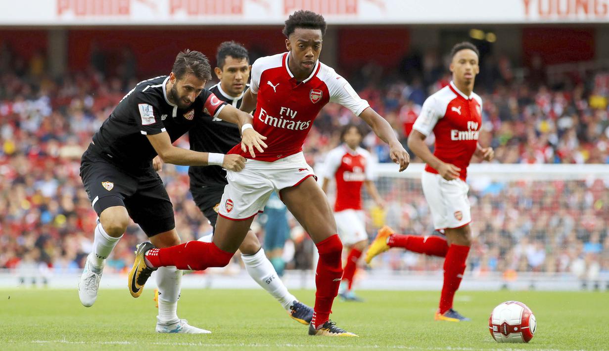 Bek Sevilla, Nicolas Pareja, berusaha merebut bola dari pemain Arsenal, Joe Willock pada laga turnamen Piala Emirates yang berlangsung di Stadion Emirates, Minggu (30/7/2017). Arsenal takluk 1-2 dari Sevilla. (AP/John Walton)