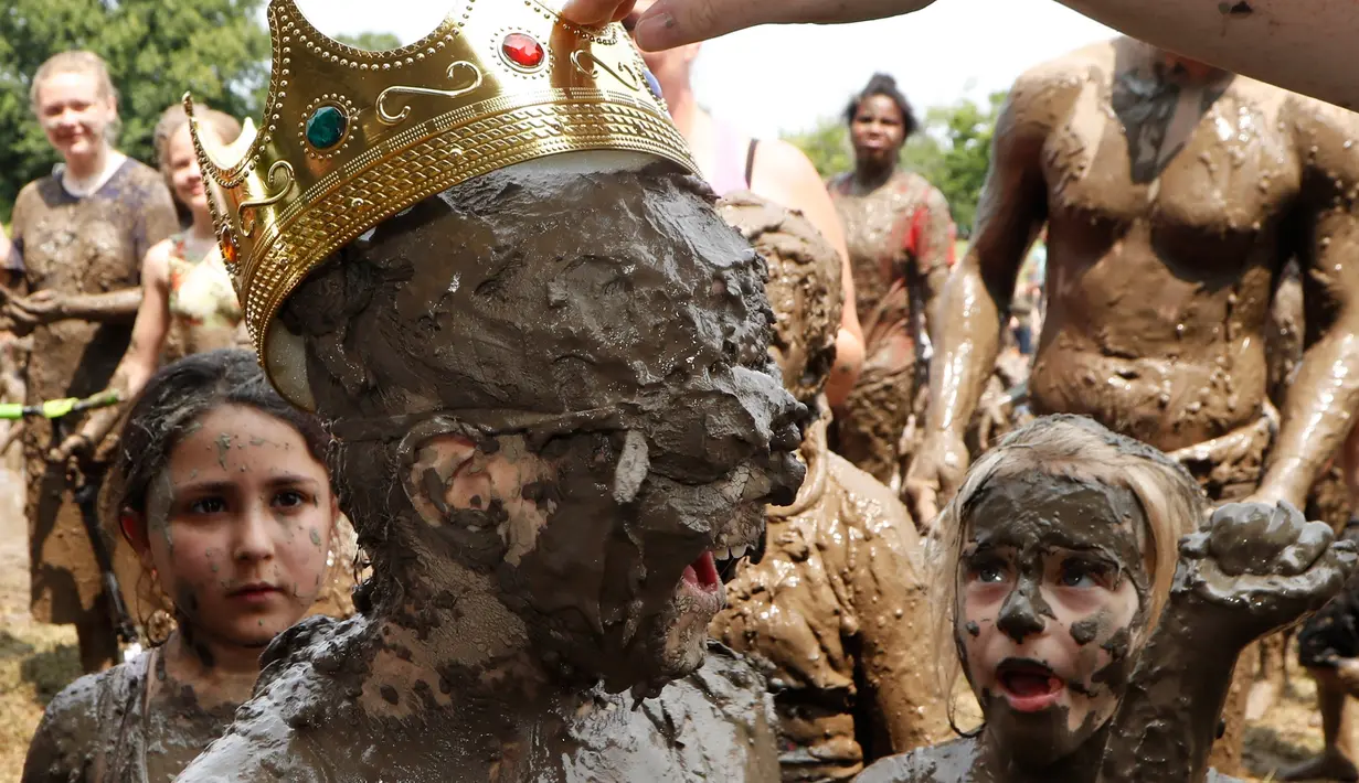 Riley Tulgetske dinobatkan sebagai Ratu Mud Day saat berpartsipasi dalam Hari Lumpur di Michigan, negara bagian AS, Selasa (9/7/2019). Para peserta perayaan yang menjadi tradisi setiap tahun ini merupakan anak-anak untuk agar mereka bersenang-senang selama liburan musim panas.  (AP/Carlos Osorio)
