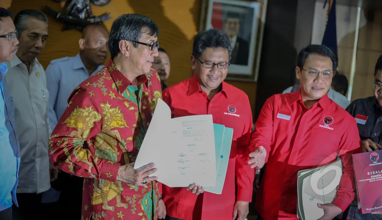 Menkumham Yasonna Laoly memperlihatan berkas yang diserahkan Hasto Kristianto di Kantor Kemenkumham, Jakarta, Rabu (6/5/2015). Kedatangan Hasto untuk menyerahkan susunan Kepengurusan DPP PDIP periode 2015-2020 kepada Yasonna. (Liputan6.com/ Faizal Fanani)