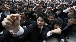 Mahasiswa Jepang meneriakan slogan jelang mengikuti acara bursa kerja di sebuah teater terbuka di Tokyo (25/2). Tujuan acara ini mendorong semangat sekolah dan mahasiswa sebelum mencari kerja. (REUTERS/Issei Kato)