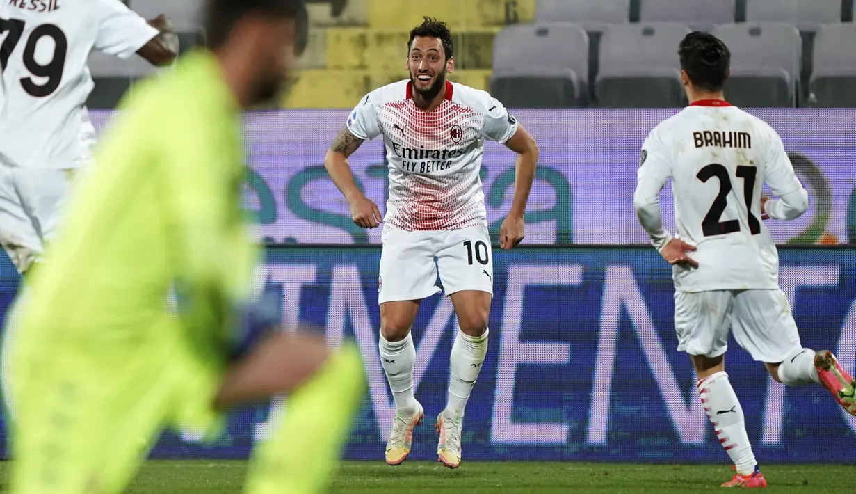 Gelandang AC Milan, Hakan Calhanoglu (tengah) berselebrasi usai mencetak gol ke gawang Fiorentina pada pertandingan Liga Serie A Italia di stadion Artemio Franchi di Florence, Italia, Senin (22/3/2021). AC Milan mengemas 59 poin dari 28 pertandingan yang sudah dilakoni. (Spada/LaPresse via AP)