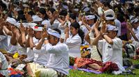 Sebelum melaksanakan upacara Melasti, umat Hindu terlebih dahulu melaksanakan persembahyangan yang dipimpin oleh seorang Romo dan Pinandita. (JUNI KRISWANTO/AFP)