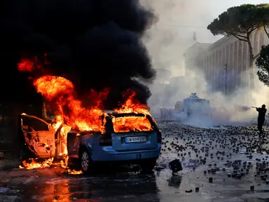 Sebuah mobil terbakar saat bentrokan pecah dalam aksi demonstrasi antipemerintah di luar kantor Perdana Menteri di Tirana, Albania, Sabtu (17/10/2026). (AP Photo/Hameraldi Agolli)