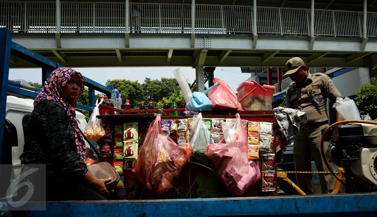 Seorang pedagang beserta dagangannya ikut di bawa petugas, Jakarta, Senin (17/10). Aktifitas ini dilakukan untuk membersihkan bahu jalan agar bersih dan dapat di gunakan kembali sebagai fungsinya. (Liputan6.com/Johan Tallo)