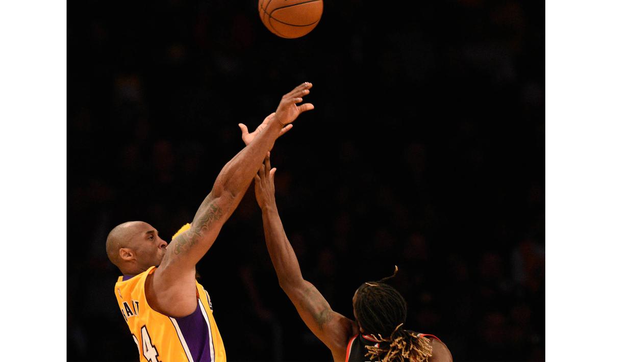 Pemain Los Angeles Lakers Kobe Bryant (kiri) melakukan tembakan melewati hadanagan pemain Toronto Raptors DeMarre Carroll (5) Pada lanjutan NBA di Staples Center, Sabtu (21/11/2015). (Reuters/Mandatory Credit: Kelvin Kuo-USA TODAY Sports)