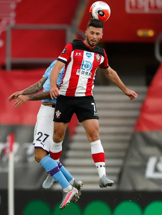 Pemain Southampton Shane Long menjauhkan bola dari jangkauan bek Manchester City Joao Cancelo dalam lanjutan Liga Inggris di St. Mary Stadium, Minggu (5/7/2020).  Manchester City gagal memetik poin penuh setelah kalah tipis 0-1 saat bertandang ke markas Southamtpon. (AP Photo/Frank Augstein, Pool)
