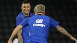 Mbappe yang merupakan top skor sementara Piala Dunia 2022 menjalani latihan dengan santai. Itu terlihat ketika dirinya banyak tertawa dan tersenyum pada saat latihan. (AP Photo/Christophe Ena)