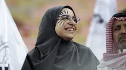 Seorang fans perempuan tersenyum saat menunggu pertandingan antara Valencia dan Real Madrid pada semifinal Piala Super Spanyol King Abdullah Sport City di kota pelabuhan Arab Saudi, Jeddah (8/1/2020). (AP Photo/Hassan Ammar)