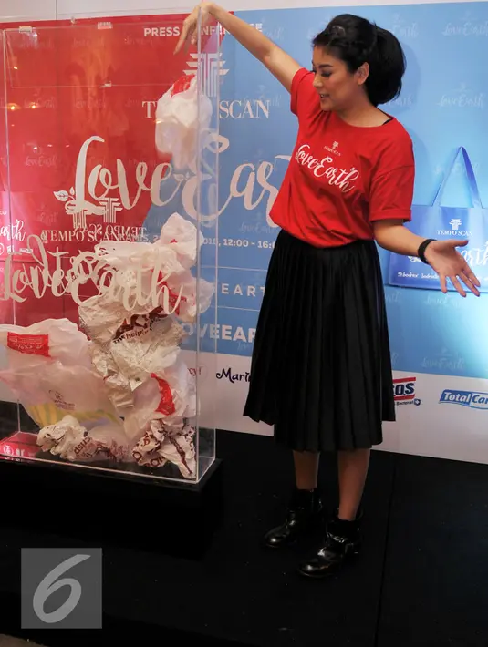 Sigi Wimala membuang sampah plastik saat acara Tempo Scan Love Earth, Jakarta, Kamis (28/4). Melalui Program Tempo Scan Love Earth, konsumen didorong untuk menggunakan tas ramah lingkungan. (Liputan6.com/Gempur M Surya)