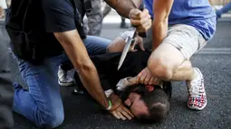 Sejumlah orang berusaha mengamankan pelaku penusukan di parade Gay Pride yang digelar di Yerusalem, Kamis (30/7/2015). Akibat penusukan tersebut, enam dari dua korban mengalami luka serius. (REUTERS/Amir Cohen) 