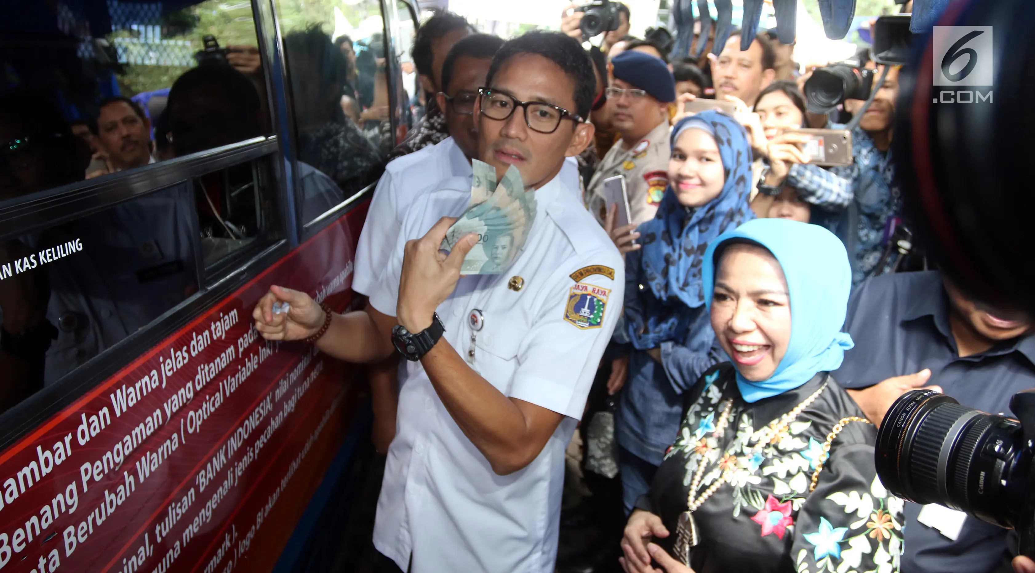 Wagub DKI Jakarta Sandiaga Uno (kiri) dan Deputi Gubernur BI Rosmaya Hadi (kanan) mengunjungi pelayanan penukaran uang di Monas, Jakarta, Rabu (23/5). Hal ini upaya BI untuk memenuhi kebutuhan uang pecahan jelang Idul Fitri. (Liputan6.com/Arya Manggala)