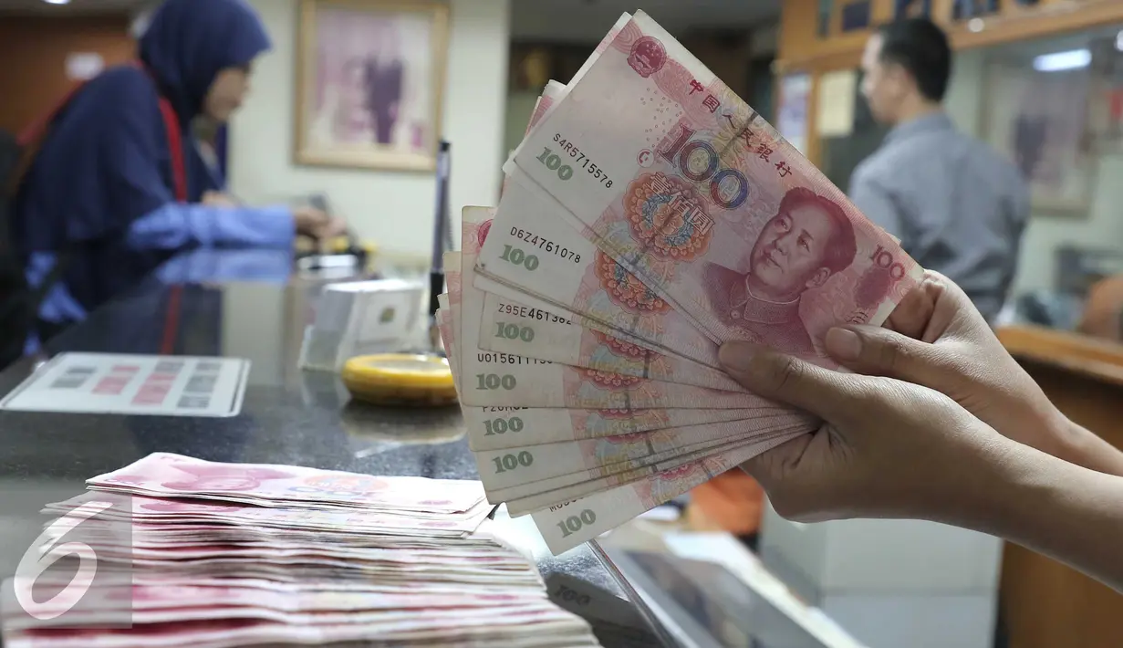 Seorang teller menunjukan  mata uang Yuan di Jakarta, Senin (30/11). Dana Moneter Internasional (IMF), Senin (30/11), resmi memasukan yuan, atau renminbi, ke dalam special drawing rights (SDR) sebagai mata uang elite dunia. (Liputan6.com/Angga Yuniar)